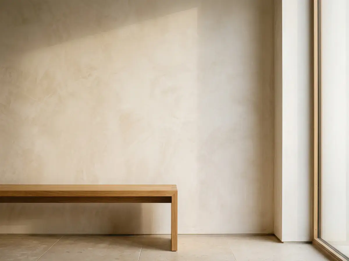 Interior wall in polished cream Venetian plaster beside an oak bench
