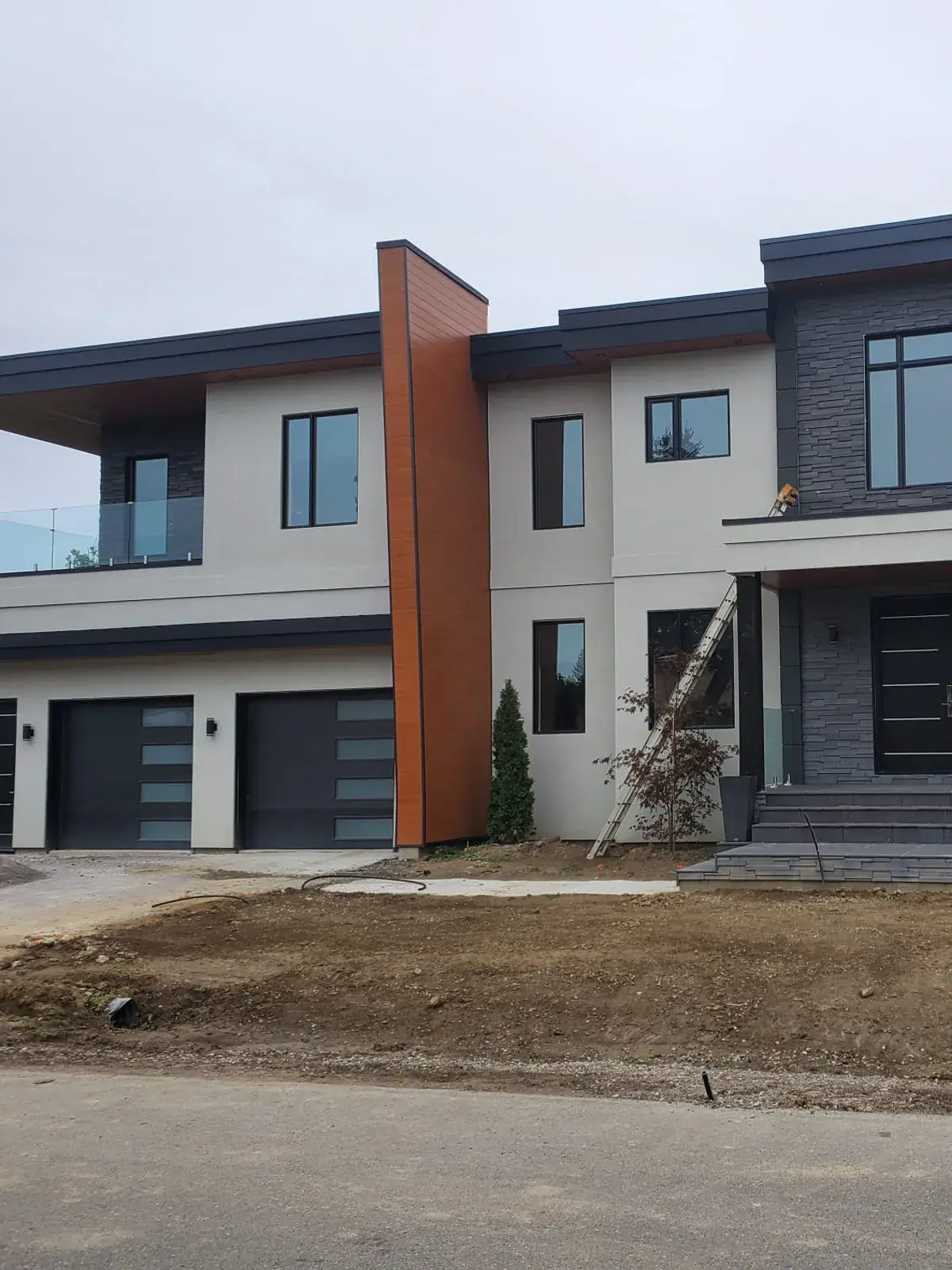 Contemporary residence with flat stucco panels, dark accents and sharp shadow lines