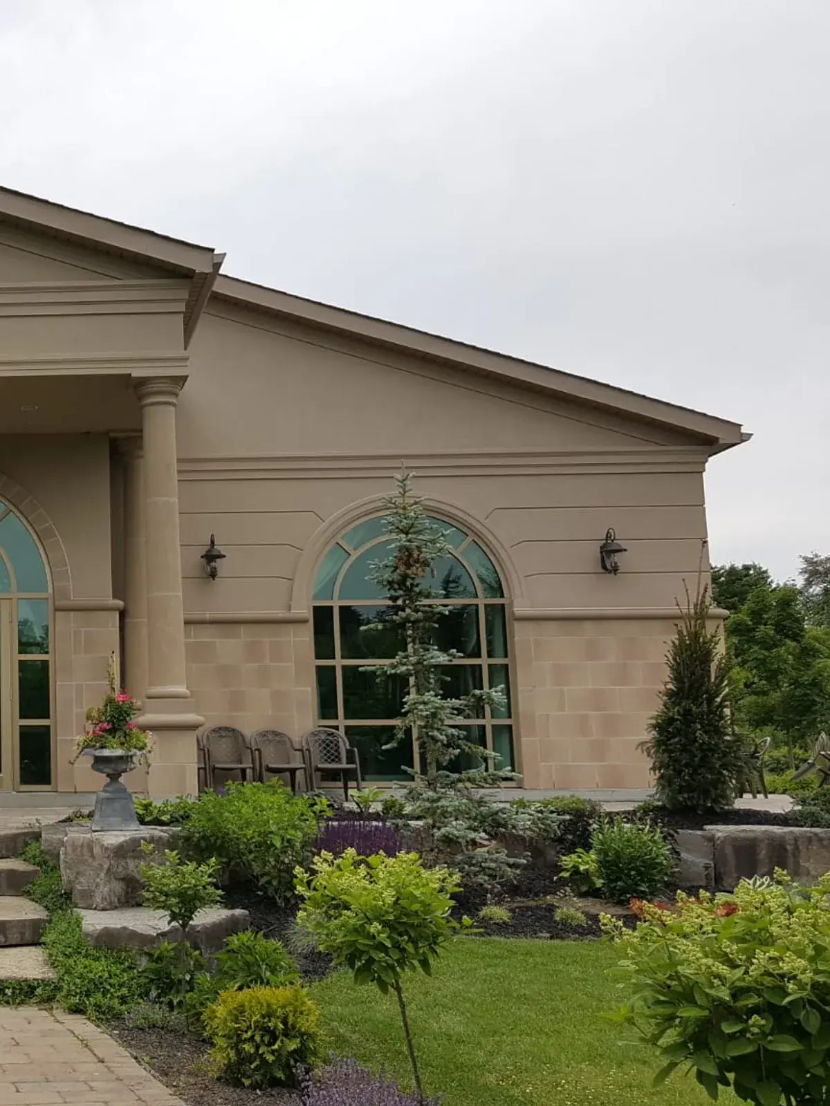 Columned portico with a stucco pediment and arched windows